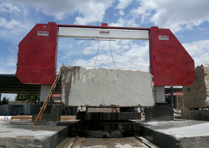 Granite quarry stone block being cut with industrial machinery for natural stone production
