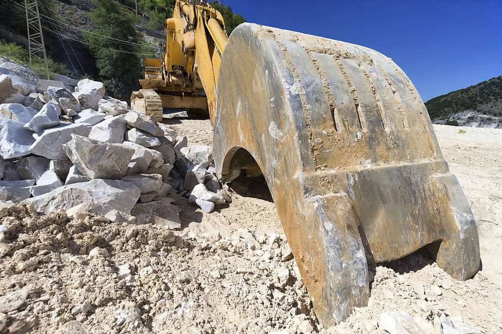 Natural stone quarrying process using heavy equipment for stone extraction